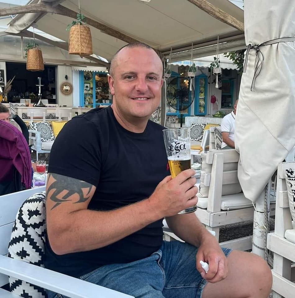 Jamie Meredith, owner of JM Fencing and Gardening Services, smiling on a sunny terrace